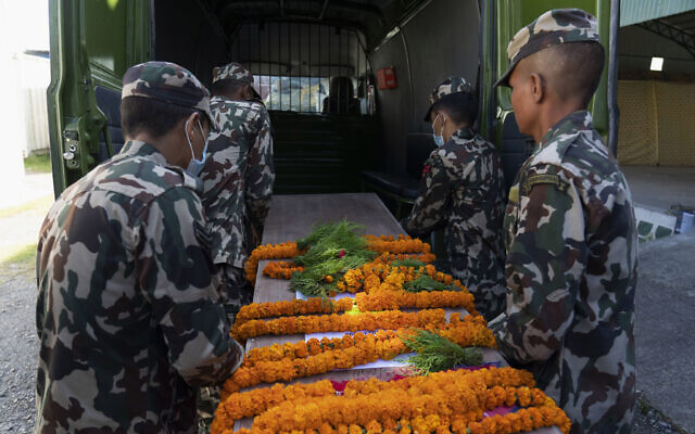 Army personnel carry one of the coffins containing bodies of Nepali nationals who were killed by Hamas attackers in Israel, at Tribhuvan International Airport in Kathmandu, Nepal, Oct. 22, 2023 (AP Photo/Niranjan Shrestha)