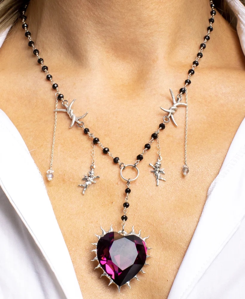 A necklace named for Amber Lynn Costello featuring angels and a big stone and thorns on a model.