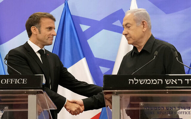 Prime Minister Benjamin Netanyahu (R) shakes hands with French President Emmanuel Macron (L) as they hold a joint press conference in Jerusalem on October 24, 2023. (Photo by Christophe Ena / POOL / AFP)
