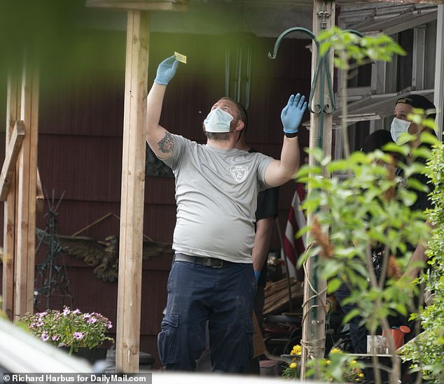 Team member pictured holding up one of the items he is collecting in the light before it goes to crime lab