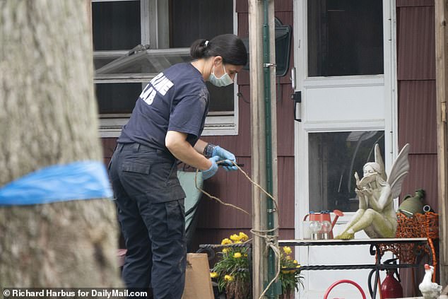 The forensic worker was seen unwinding the rope from a pole at the Heuermann property