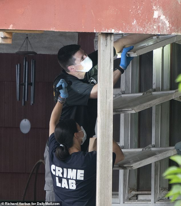 Crime lab specialists using a flashlight during the search for the paint chips