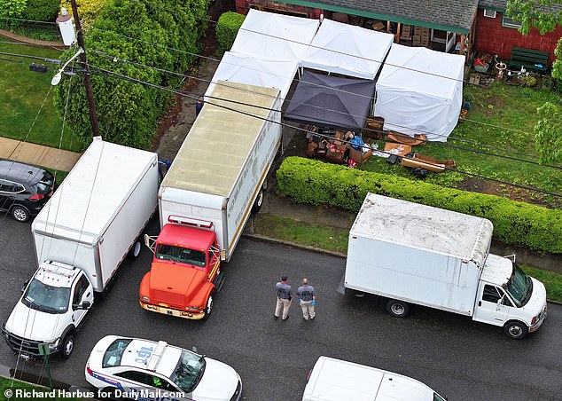 The larger truck with the red front engine is where they were loading possessions of the family to clear out the rooms to do more searching and the white box truck is actual evidence truck that goes back to the crime lab for testing