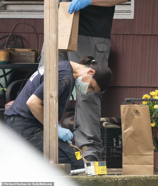 A crime lab specialists examines a rope that she labels with evidence tape