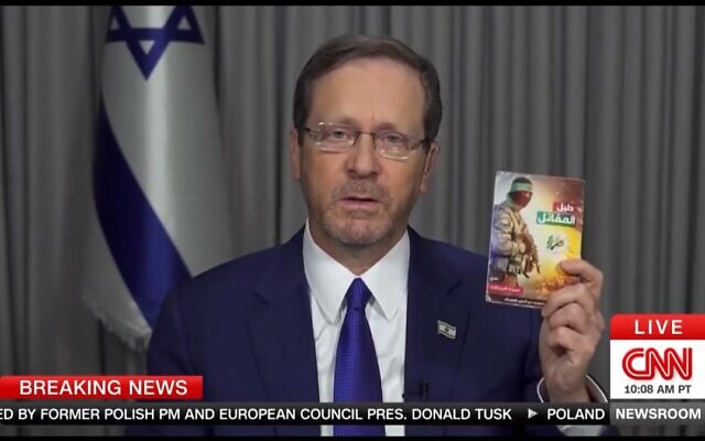 President Isaac Herzog shows a terror manual on how to kidnap and torture people taken from the body of a Hamas terrorist in an interview with CNN on October 15, 2023 (Screencapture)
