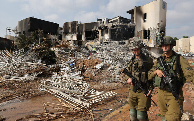 Soldiers walk in front of a police station that was damaged during battles to dislodge Hamas militants who were stationed inside, in the southern city of Sderot, on October 8, 2023. (JACK GUEZ/AFP)