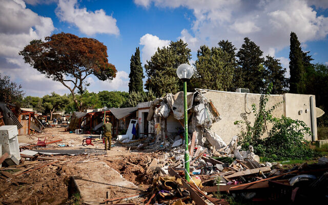 Israeli soldiers around the destruction caused by Hamas terrorists in Kibbutz Kfar Azza, near the Israeli-Gaza border, in southern Israel, October 15, 2023. (Chaim Goldberg/Flash90)