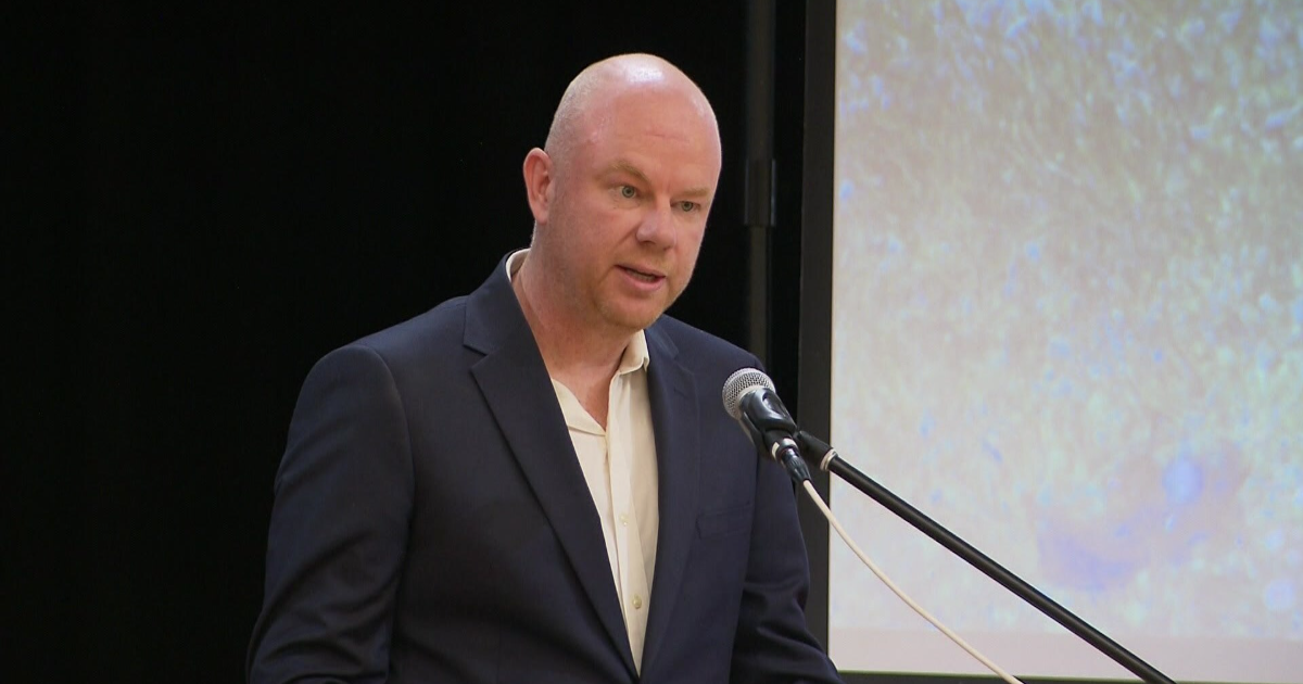 Simon Patterson stands at a microphone.