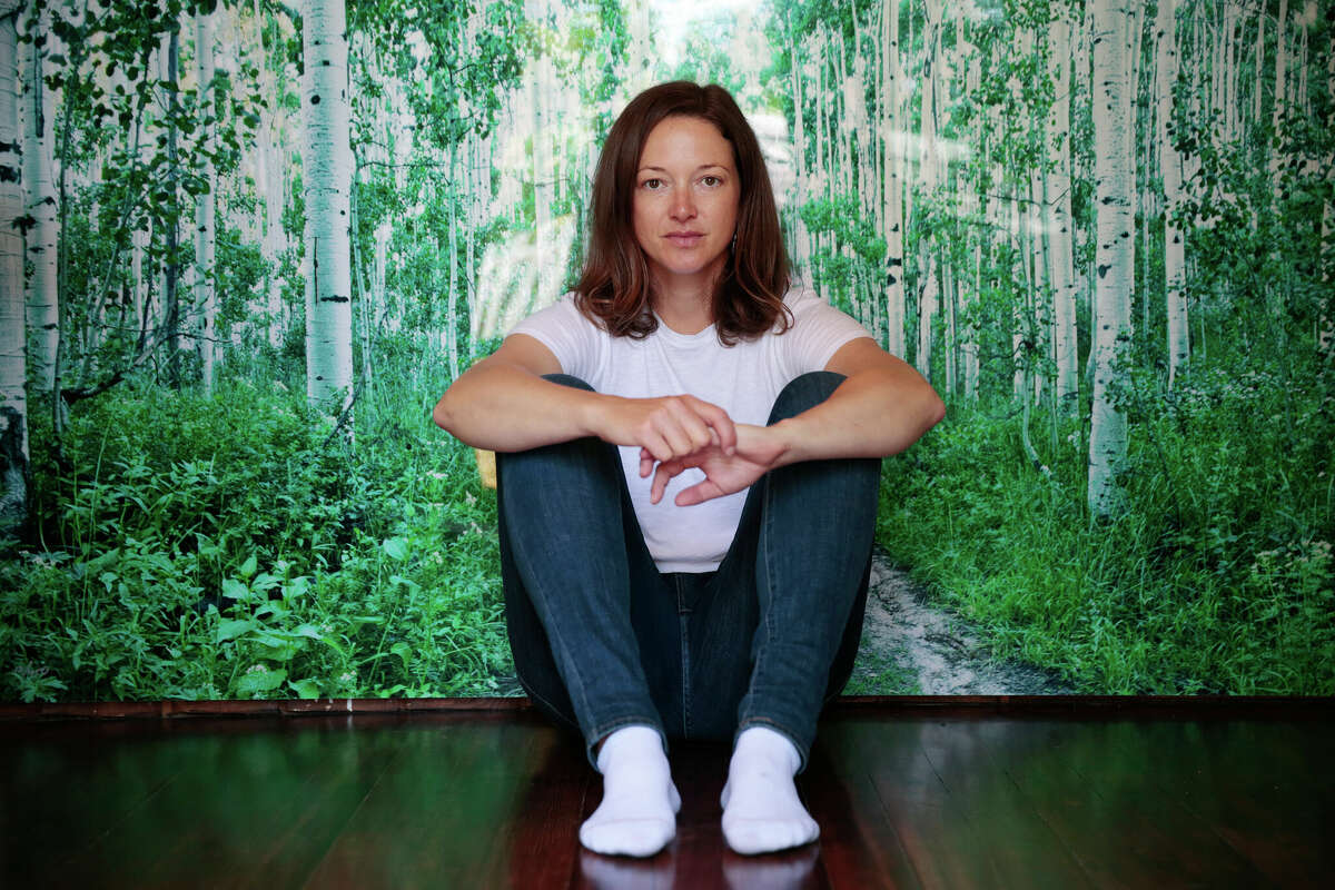 Adrienne Spohr sits in front of a photograph her mom gave her in her Petaluma home. She sued her sister and her sister’s husband, former professional baseball player Daniel “Danny” Serafini, in June, accusing them of being involved in the deaths of her parents.